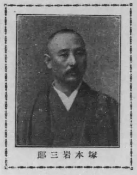 A black and white portrait of a Japanese man with a receding hairline and a bushy mustache. He is wearing dark kimono.