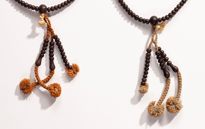 Closeup of the three tassels on the end of the wooden bead rosaries.