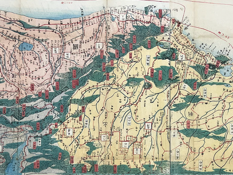 A segment of a printed map showing land topography in green and yellow with labels.