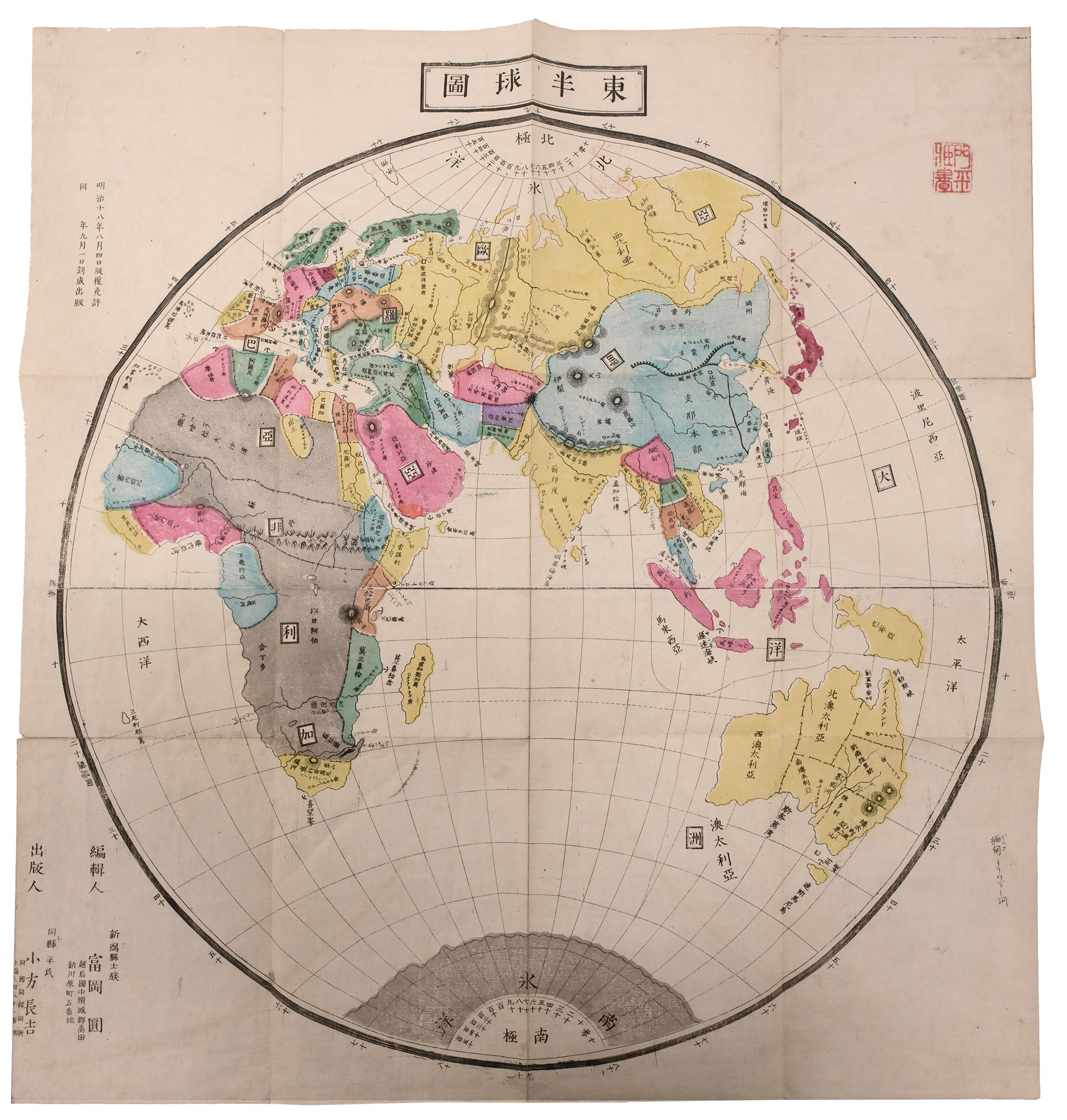 A printed map of the world, showing Asia, Africa, and Oceania in bright blue, yellow, and pink colors.