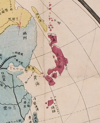 A closeup of a printed map picture of Japan, seen in dark pink.