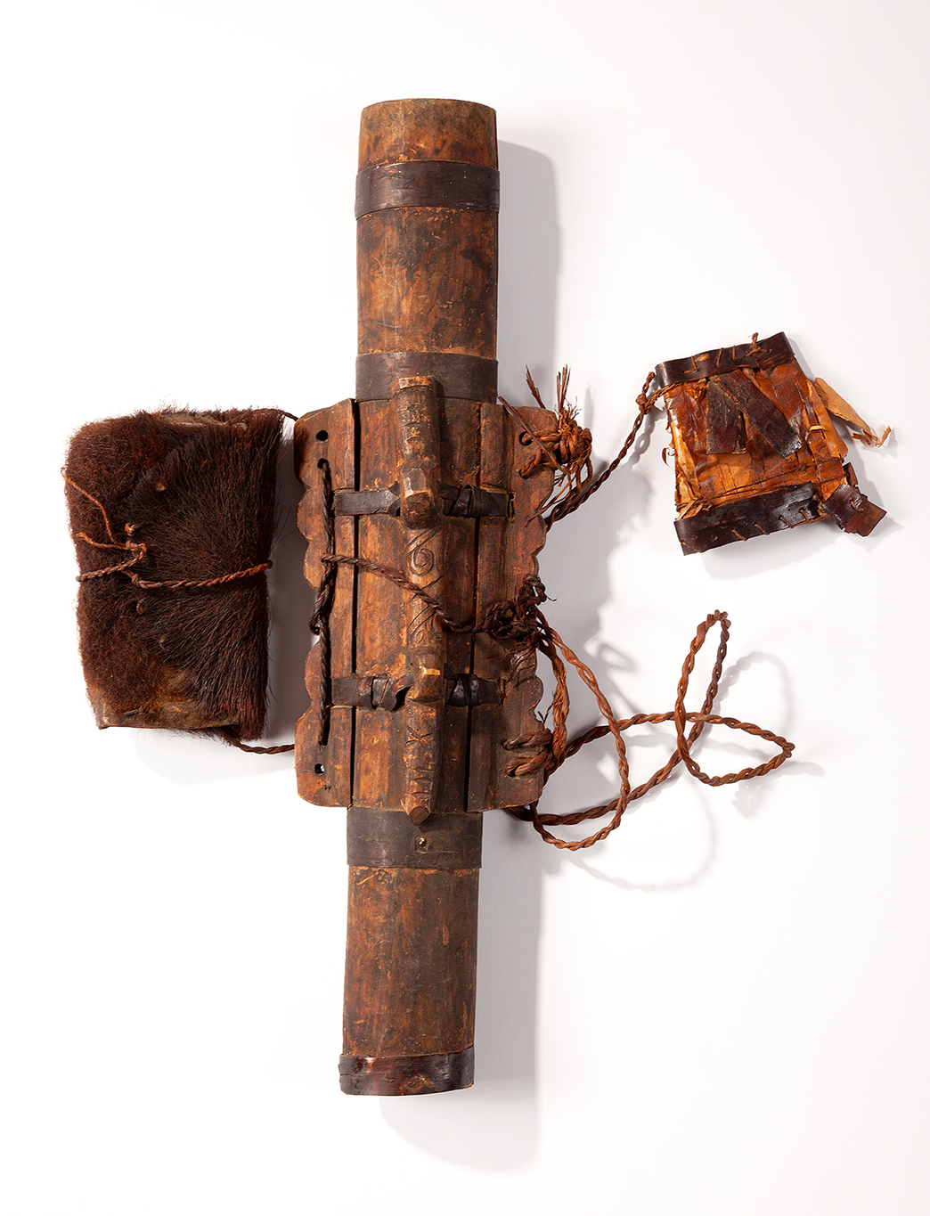 An Ainu wooden quiver set with a brown bearskin pouch and a slightly flattened quiver cap.