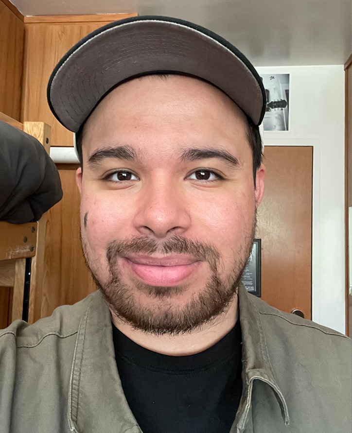 A man smiling and wearing a baseball cap.